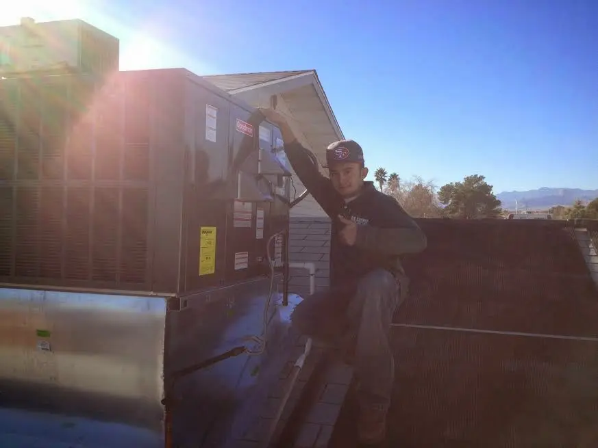 HVAC technician performing AC Tune-Up on a rooftop unit in Lenexa